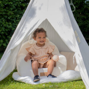 Meisje op kinderstoeltje in tipitent