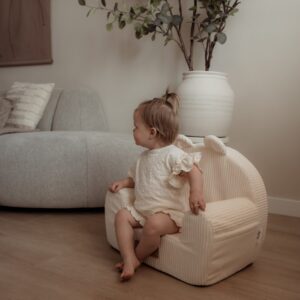 Klein meisje die zit op kinderstoel wit